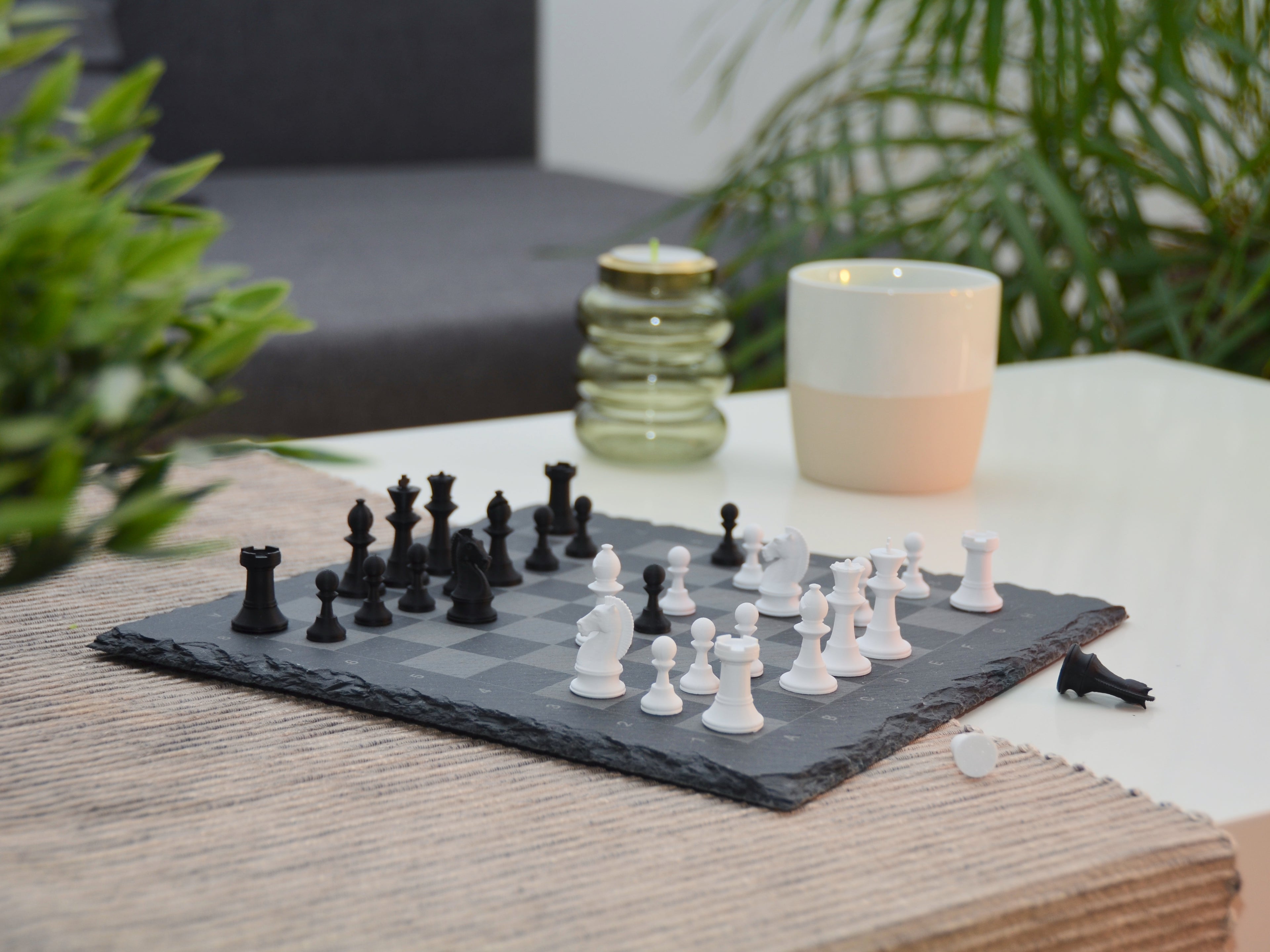 Nahaufnahme modernes Schachspiel: Matte Oberfläche der 3D-gedruckten Figuren auf der rauen Schieferstruktur.