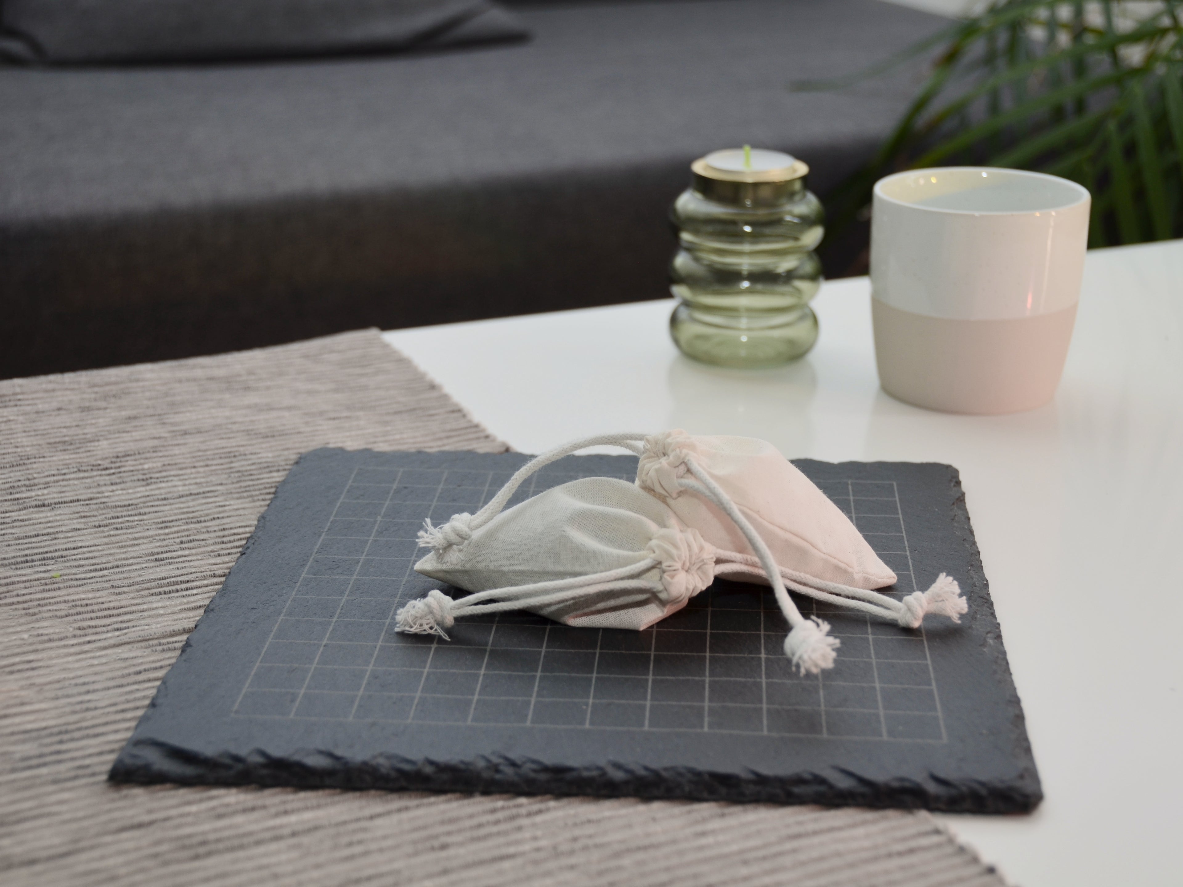 Go Spielset aufgeräumt: Verschlossener Jutebeutel auf dem leeren 13x13 Spielfeld liegend.