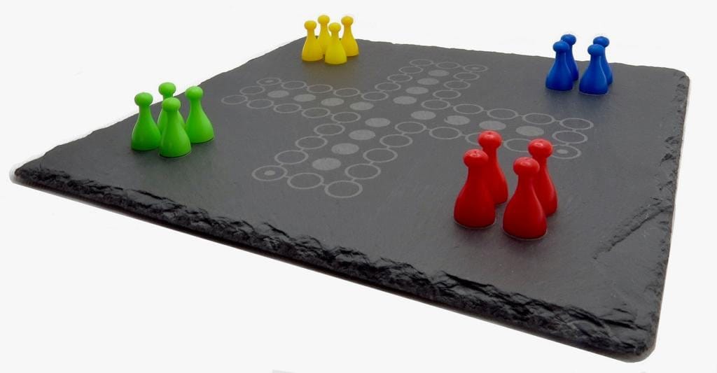 Ludo Spielsituation auf Schiefer: Bunte Spielfiguren auf dem edlen grauen Steinbrett.
