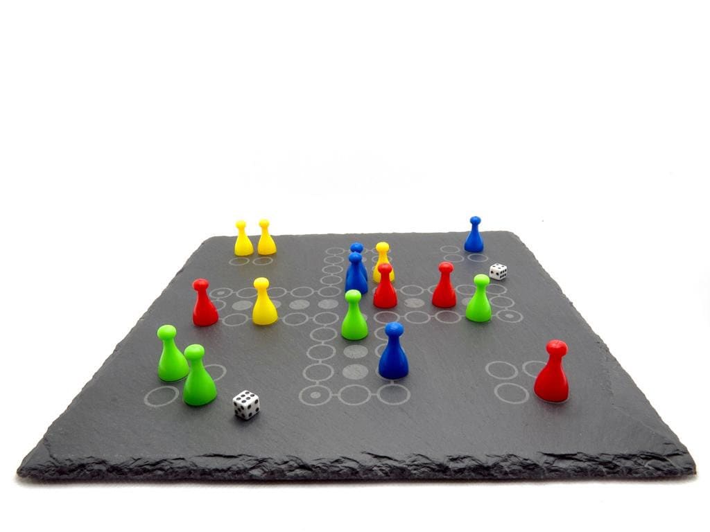 Ludo Spiel aus Schiefer: Edles Brettspiel im Mensch-ärgere-dich-nicht Stil mit bunten Figuren auf dunklem Naturstein.