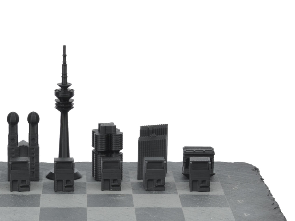 Seitenprofil des München Schachsets: Silhouette der Skyline-Figuren inklusive Olympiaturm auf grauem Schieferbrett freigestellt.