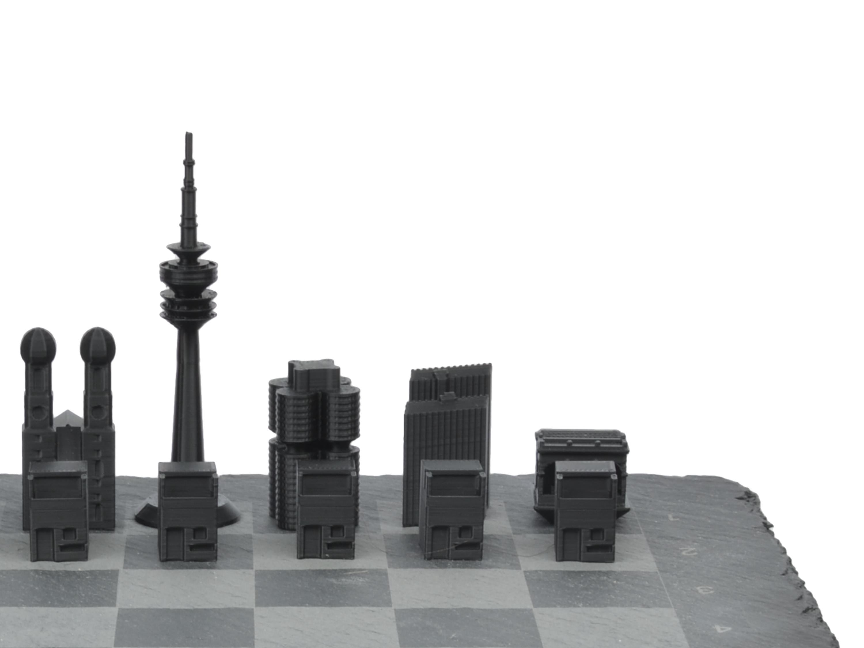 Seitenprofil des München Schachsets: Silhouette der Skyline-Figuren inklusive Olympiaturm auf grauem Schieferbrett freigestellt.